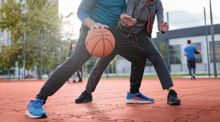 2 Menschen spielen auf Gummiboden Basketballfeld