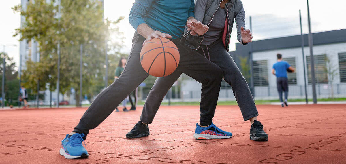 2 Menschen spielen auf Gummiboden Basketballfeld