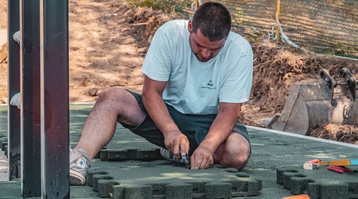 Handwerker am Fallschutzmatten Schneiden