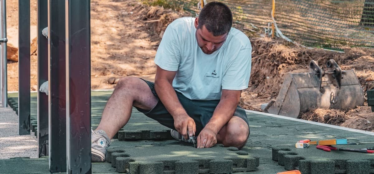 Handwerker am Fallschutzmatten Schneiden